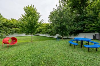 a group of picnic tables and benches in the grass